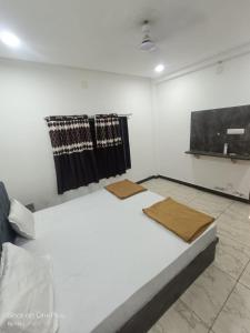 a bed in a room with black and white curtains at Dwarka Sai Palace in Dwarka