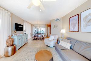 ein Wohnzimmer mit Sofa und Fernseher in der Unterkunft Bluewater 1006 in Orange Beach
