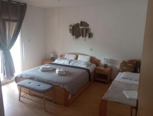 una camera da letto con due letti e una finestra di Apartmani Ćućić a Lopar Altre 20 foto