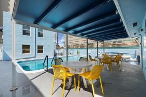 Un patio con mesa y sillas y una piscina. en Oceanfront Bliss Cozy 1BR by Beach Free Parking, en Hollywood