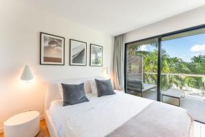 古斯塔维亚Rêve de Saint Barth - Vue Mer - Piscine Chauffée & Jacuzzi的卧室里有一张白色的床和一扇大窗户