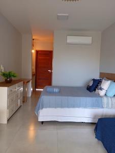 a bedroom with a large bed and a wooden door at Barra Grande Flat Manaí in Marau +23 photos
