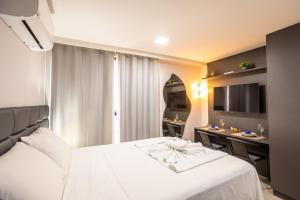 a hotel room with a white bed and a desk at Way Tambaú #C4 - Duplo deluxe by Carpediem in Tambaú +42 photos