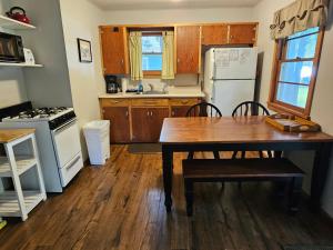 eine Küche mit einem Tisch und einem weißen Kühlschrank in der Unterkunft Brookhaven 3 in Maple City + 16 Fotos