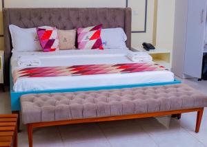 a large bed with a bench in a room at cyro reservations in Nalakonge