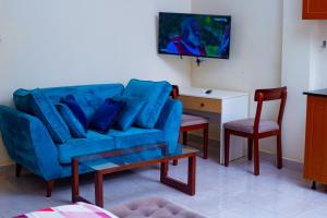 a living room with a blue couch and a table at cyro reservations in Nalakonge