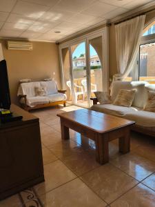 een woonkamer met een bank en een salontafel bij Villa with super swimming pool in Gran Alacant