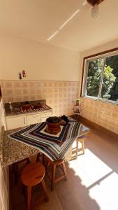 a kitchen with a table with chairs and a stove at Casa ampla próxima à Rua do Lazer in Santa Teresa