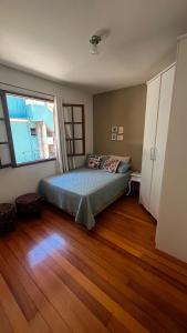 a bedroom with a bed and a large window at Casa ampla próxima à Rua do Lazer in Santa Teresa