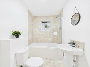 a white bathroom with a tub and a toilet and a sink at NEW No7 Saxon Way by Signature Stays in Upton Warren +30 photos