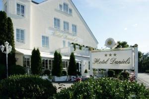 un gran edificio blanco con un cartel delante en Hotel Daniels en Hallbergmoos