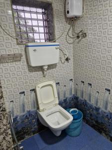 a bathroom with a toilet and a window and water bottles at Quietude in Khalapur +14 photos