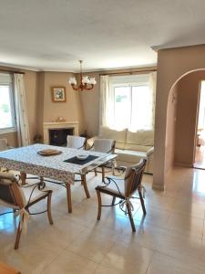 een woonkamer met een tafel, stoelen en een bank bij Villa with super swimming pool in Gran Alacant