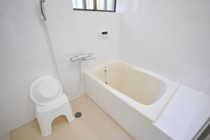 a bathroom with a tub and a toilet and a sink at IZUMI HOUSE - 成田空港から車で22分 - 最大8名 - 駐車場2台完備 - Switch有 - 10月28日以降ペット歓迎 in Yachimata +49 photos