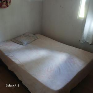 a small bed in a small room with a white mattress at Sítio Promessa in Benevides