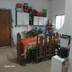 a kitchen with a table with a red table cloth at Sítio Promessa in Benevides