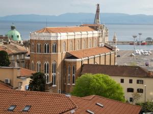 a large brick building with red roofs in a city at Apartment Aida in Rijeka