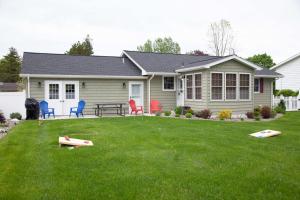 a house with chairs and a table in the yard at Canalside Cottage 3BR Lake Access Dock Fire Pit in Geneva