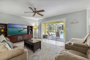 a living room with two couches and a flat screen tv at 601 Benedictine Ter in Sebastian