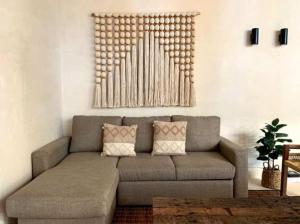 una sala de estar con un sofá gris en una habitación en Charming 2BR Ground Floor with Private Pool, en Tulum