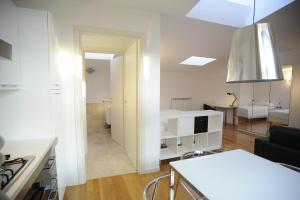 ein Wohnzimmer mit einer Küche und ein Wohnzimmer mit einem Tisch in der Unterkunft La Maison del Capestrano in Mailand