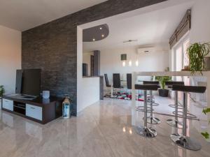 a living room with bar stools and a tv at Apartment Black@white in Klenovica
