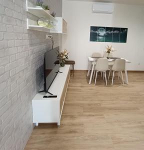 - un salon avec un mur en briques blanches dans l'établissement Apartamentos Luz de Luna B, à Churriana de la Vega