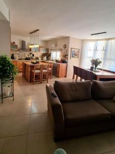 a living room and kitchen with a couch and a table at Best In Ramat Poleg in Netanya