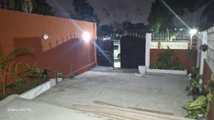 a gate to a house with a driveway at night at Villa Llona in Motsouémbé