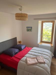 Un dormitorio con una cama grande y una ventana. en Auberge de Boffres, en Boffres