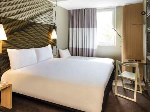 a large white bed in a room with a window at ibis Paris Saint-Denis Stade Sud in Saint-Denis