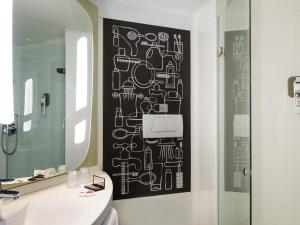 a bathroom with a black and white wall at ibis Paris Saint-Denis Stade Sud in Saint-Denis +40 photos