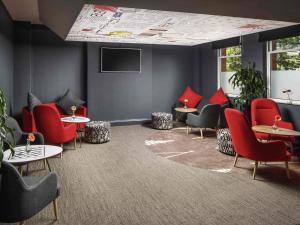 コベントリーにあるイビス コヴェントリー センターの赤い椅子とテーブルのある待合室