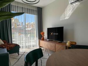a living room with a tv and a large window at Qoople Legend A - Stylish accommodation by the sea in Alanya