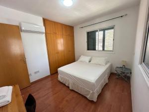 a bedroom with a white bed and a window at Spacious City Center - Suite 203 in Nicosia