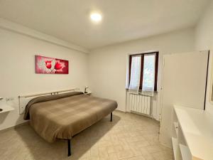 Un dormitorio con una cama y un cuadro en la pared. en Appartamenti Estivi Anna e Pino, en Rio Marina