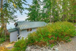 a small house in the middle of a forest at Outdoor Kitchen and Canal Views Cabin in Quilcene! in Seabeck