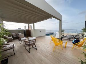 a patio with chairs and tables and a view of the ocean at Stunning 2 Bedroom Apartment Overlooking the Ocean in Dakar +10 photos