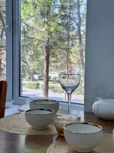 Un grupo de cuencos y una copa de vino sobre una mesa. en Уютная квартира, en Karakol