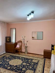 sala de estar con espejo y silla en Уютная квартира, en Karakol 11 fotos más