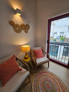 a living room with a couch and a chair and a window at Vila Real Central House in Vila Real