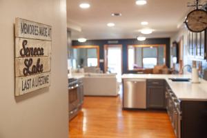 a kitchen with stainless steel appliances and a living room at Break Away Hot Tub Lake Access & Game Rooms in Teall Beach +35 photos