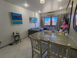 a kitchen and living room with a table and chairs at Quarto e Sala completo com Cozinha, Ar condicionado, Wifi e Camareira in Salvador