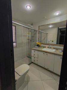 a bathroom with a toilet and a sink and a mirror at Quarto e Sala completo com Cozinha, Ar condicionado, Wifi e Camareira in Salvador