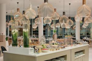 a restaurant with many lights hanging from the ceiling at NH Toulouse Airport in Blagnac