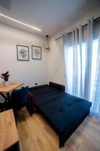 een slaapkamer met een blauw bed en een tafel bij Coloris Rubrum room in Thessaloniki