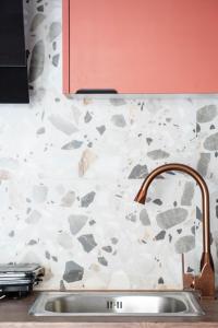 een wastafel in een keuken met een stenen muur bij Coloris Rubrum room in Thessaloniki