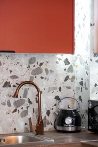 een waterkoker op een aanrecht naast een wastafel bij Coloris Rubrum room in Thessaloniki +17 foto's