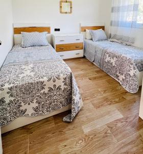 アシラにあるDar Deyafaの木製の床の部屋にベッドが2つあります