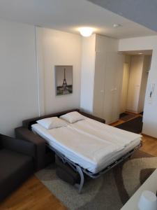 a bedroom with a bed and a couch in a room at City Center apartment at the Bus Station With balcony and sauna in Turku